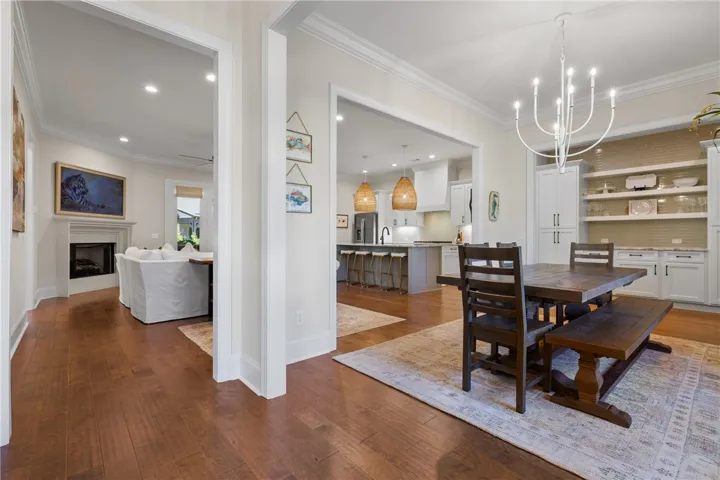 Classic crown molding and hardwood flooring elevate this flowing, open-concept dining space.