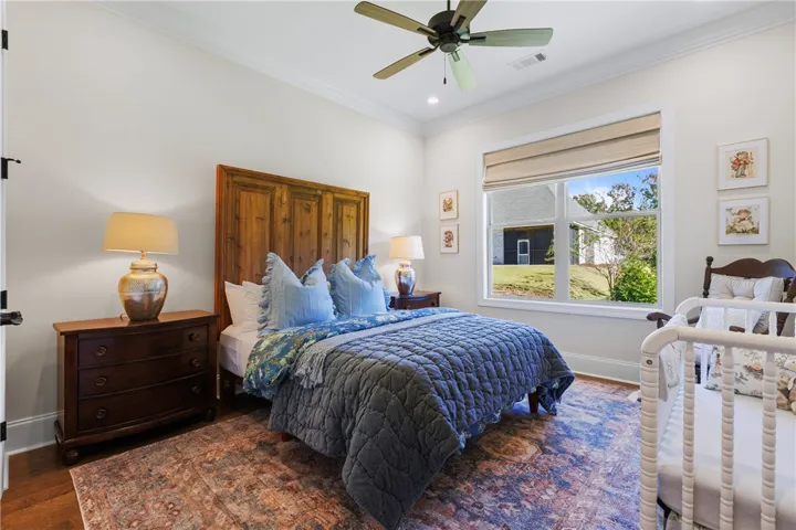 Rich hardwood flooring and crown molding frame this inviting space featuring a large window.