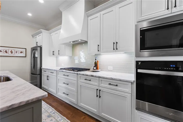 Elegant crown molding and classic stone counters define this sophisticated cooking space.