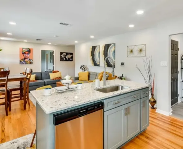 Granite counters and hardwood floors define this welcoming open floorplan kitchen.