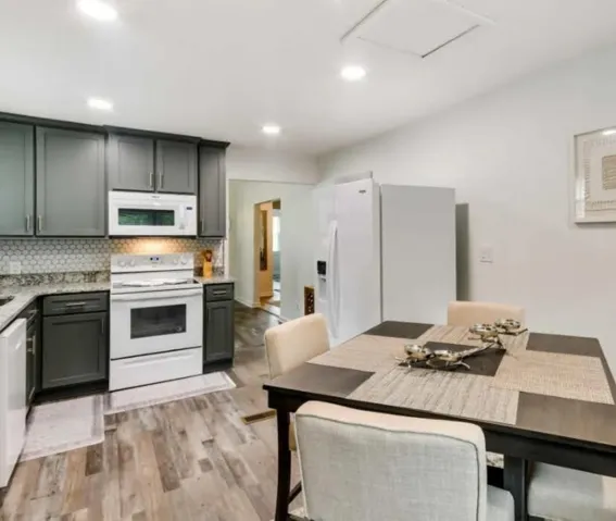 Gleaming floors run through a kitchen complete with granite counters and cabinetry.