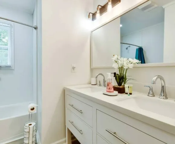 Clean lines and dual sinks define this well-appointed washroom space.