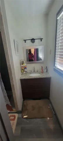 An elegant vanity with stone countertops highlights this cozy bathroom space.