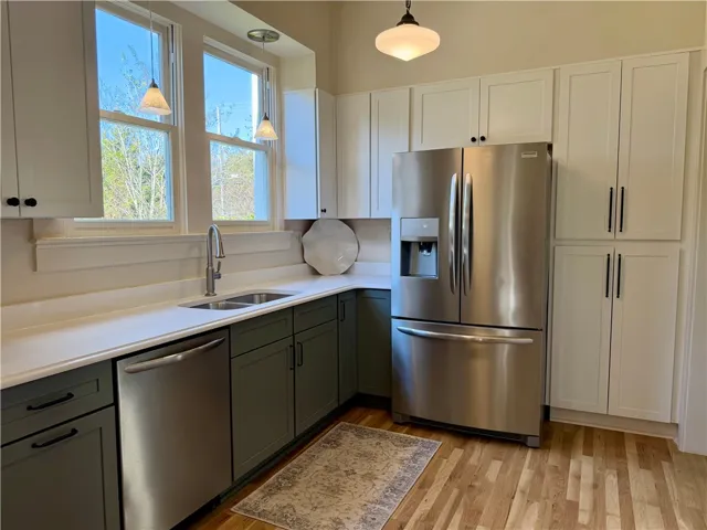 Thoughtfully remodeled kitchen with new two-toned shaker cabinets w/soft close drawers, striking quartz counters, stainless steel appliances & multiple pantry spaces