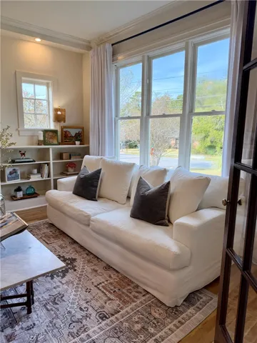Gleaming hardwood floors run through a sunlit space framed by tall windows and timeless built-ins. Talk about THE place for a Christmas tree!