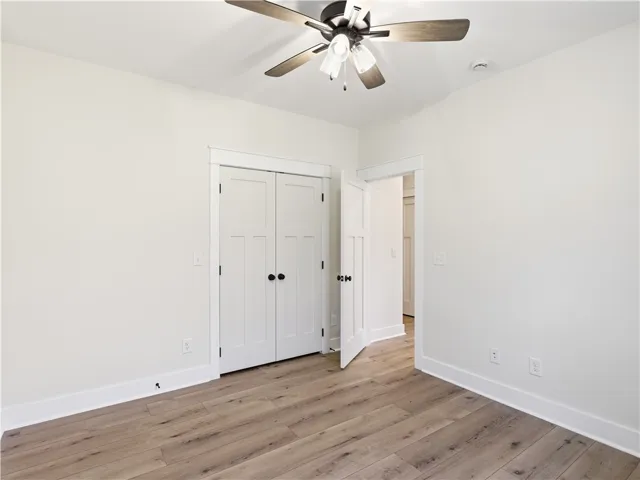 Smooth wood-look flooring and crisp white trim define this versatile secondary bedroom space.