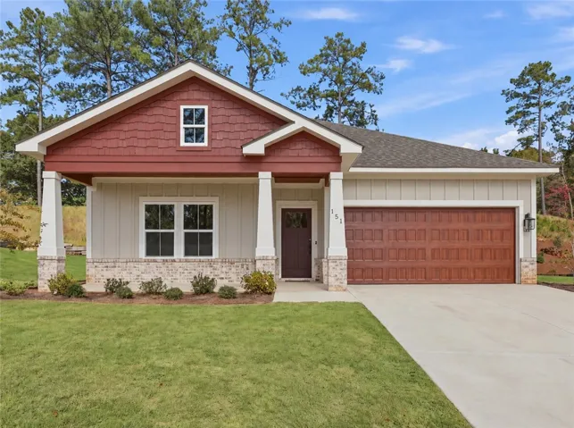 Craftsman architectural elements highlight the inviting covered front porch and concrete driveway.