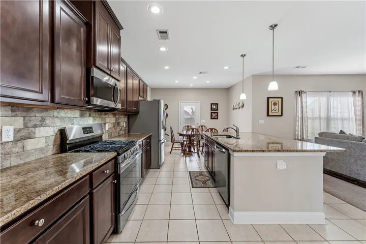 Rich wood cabinetry and expansive granite countertops define this functional kitchen workspace.