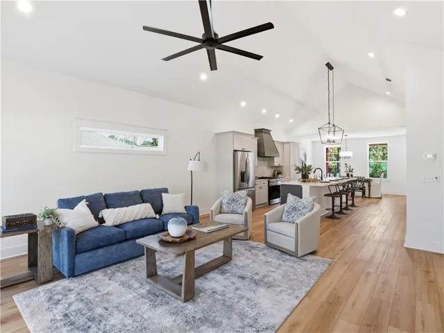 Soaring vaulted ceilings and rich wood floors anchor this airy, open-concept living space.