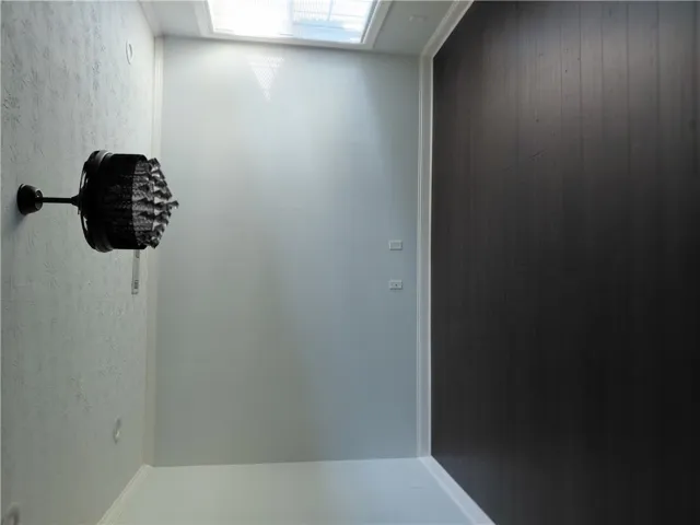 Natural light pours through a large overhead skylight, illuminating the crisp walls and clean trim.