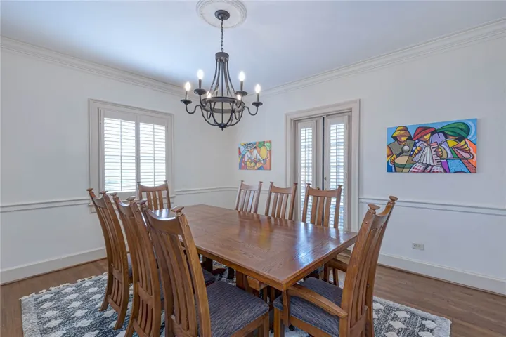 Rich hardwood flooring complements the classic chair rail molding and elegant overhead chandelier lighting.