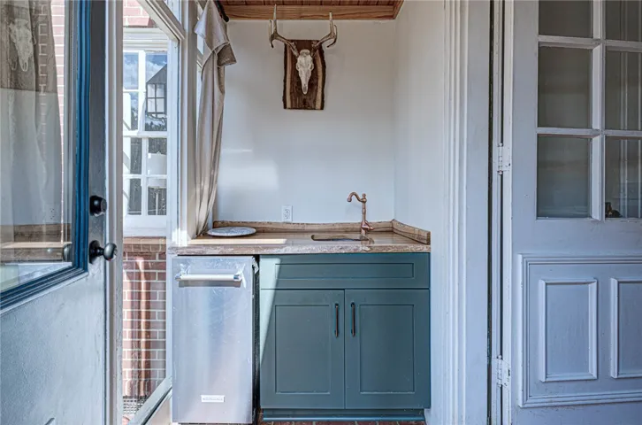 Natural wood ceilings and stone countertops create a rustic wet bar niche off the​​‌​​​​‌​​‌‌​‌‌​​​‌‌​‌​‌​‌​​​‌​​ kitchen.