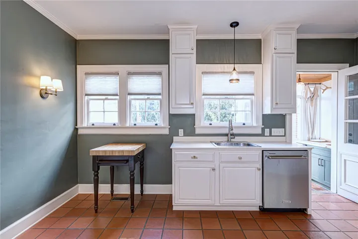 Rich tile flooring and classical moldings frame this charming workspace with garden views.