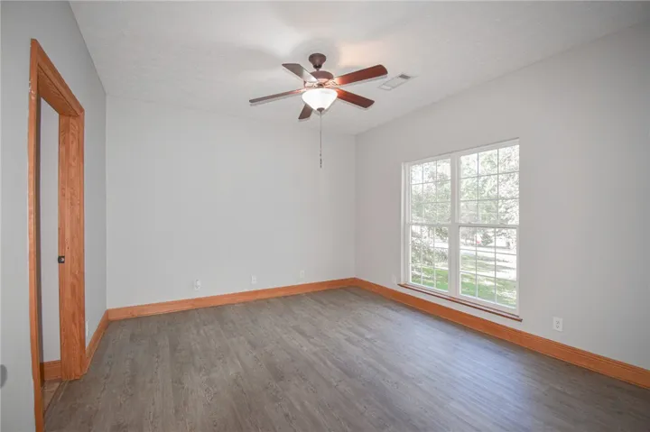 Natural light floods this versatile space featuring rich wood trim and durable vinyl flooring.
