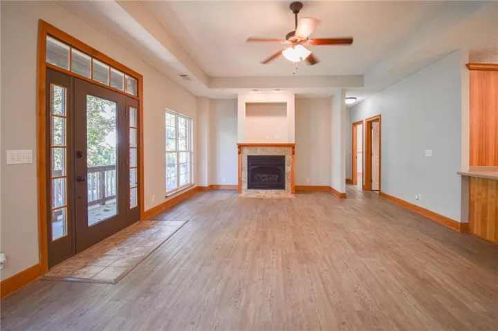 Gleaming wood-look floors, a classic fireplace, and a tray ceiling define this open living space.