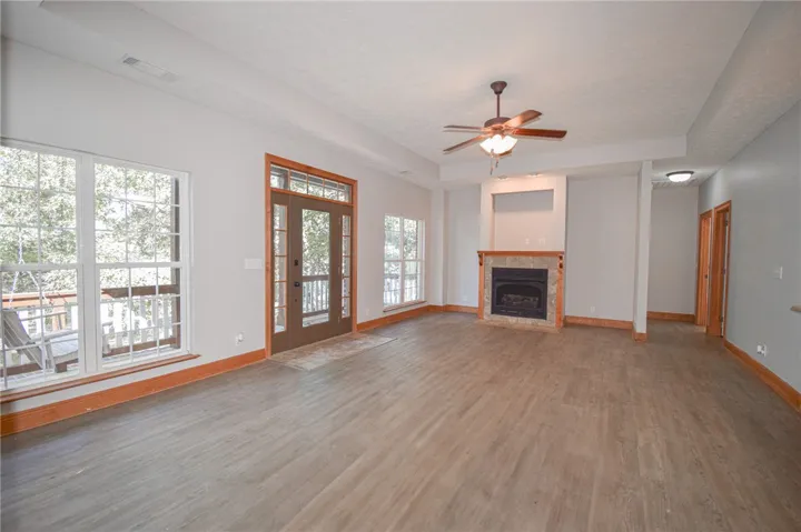 Warm wood-trimmed windows and doors frame peaceful outdoor views from this fireplace-warmed living space.