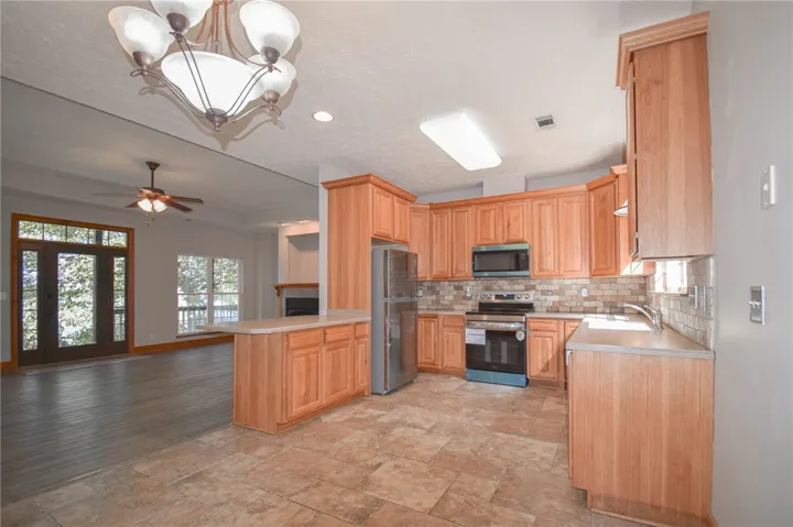 An open kitchen layout flows seamlessly into the main living space with durable tile floors.