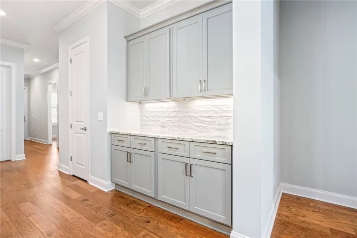Convenient side server with additional cabinetry and decorative under counter lighting
