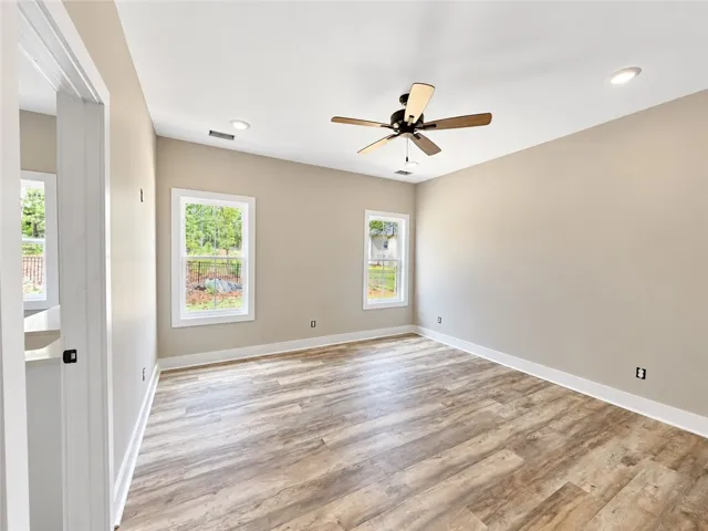 Hardwood floors and natural light define this inviting Primary bedroom.