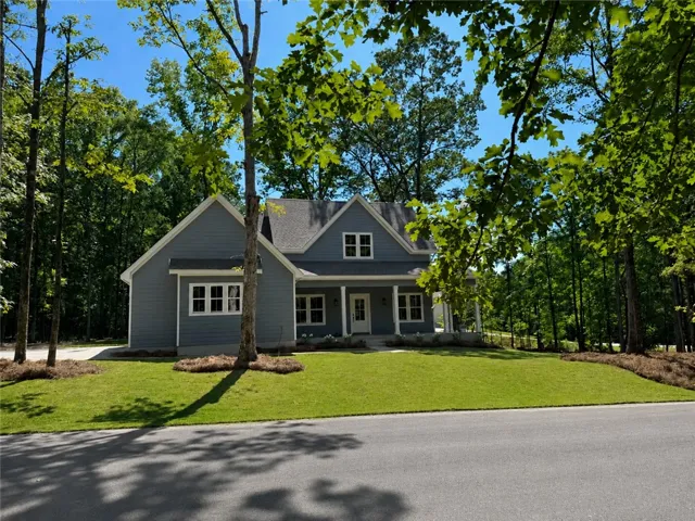 A classic gabled roofline and welcoming wrap- around front porch highlight this charming home.