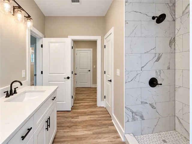 Elegant tile details and quartz counters elevate this modern secondary bathroom.
