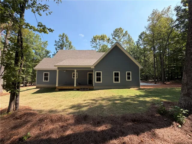 Mature trees frame the exterior of this modern home with a covered rear porch.