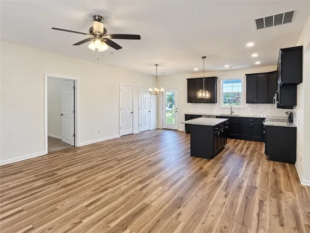 Gleaming wood-look floors anchor a spacious open-concept kitchen and living area.