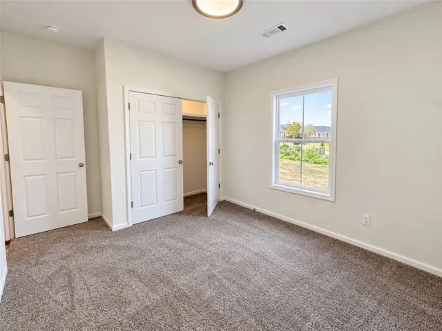 Plush carpeting anchors this comfortable bedroom complete with a built-in closet and outdoor views.