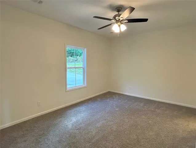 Soft plush carpeting anchors this versatile room under a tall ceiling.