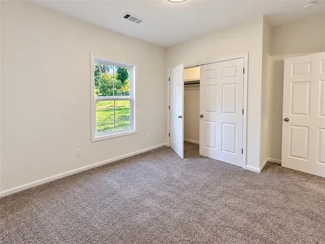 Soft plush carpeting and natural light frame this comfortable bedroom with ample closet storage.