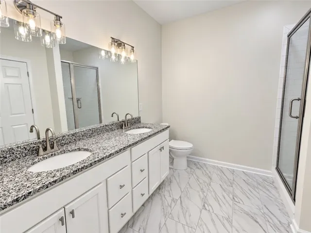 Marble-patterned flooring and stone countertops elevate this modern bathroom design.
