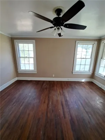 Rich hardwood floors and classic multi-pane windows anchor this versatile, light-filled space.