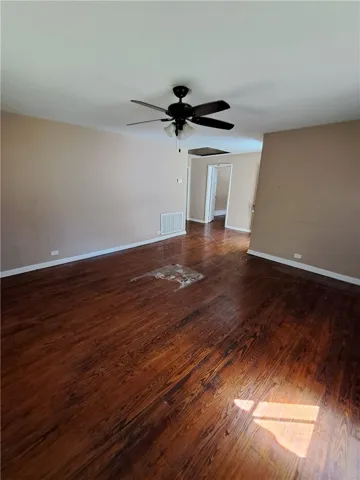 Rich hardwood floors anchor this open living space leading to adjoining hallways.