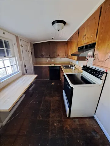 Natural wood cabinetry and matching laminate countertops anchor this functional cooking space.