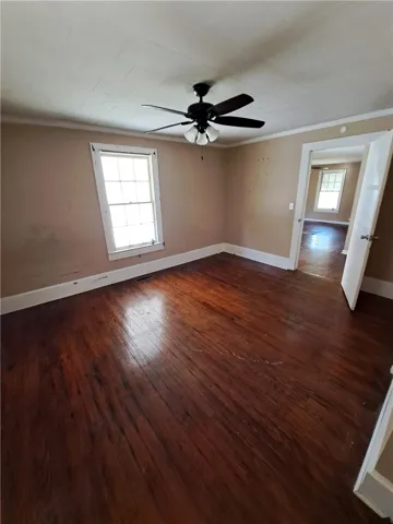 Rich hardwood floors and classic crown molding anchor this versatile interior space.