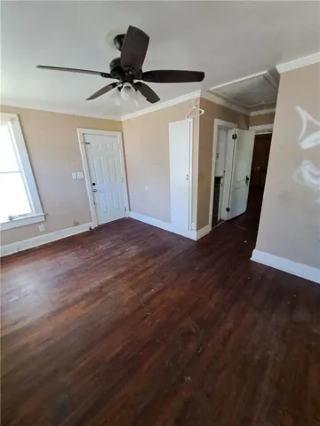 Original hardwood floors and classic crown molding anchor this versatile living area.