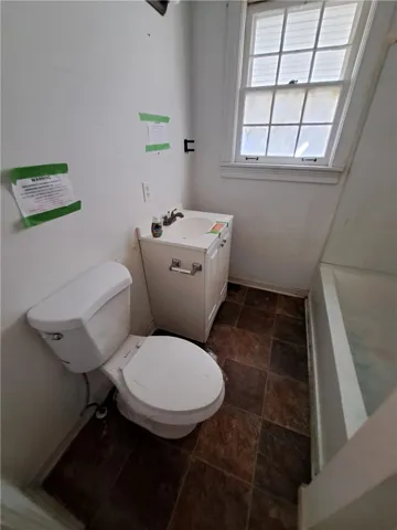 Functional bathroom space features a classic multi-pane window and a built-in tub.
