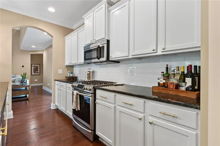 Rich hardwood flooring anchors the clean-lined cabinetry and granite countertops in this culinary space.