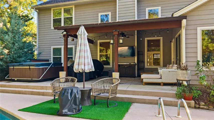 A spacious covered patio sits alongside the pool deck, offering an ideal setting for outdoor relaxation.