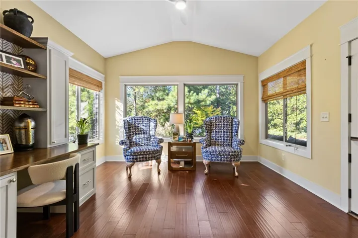 Rich hardwood floors and soaring vaulted ceilings define this sunlit home office space.