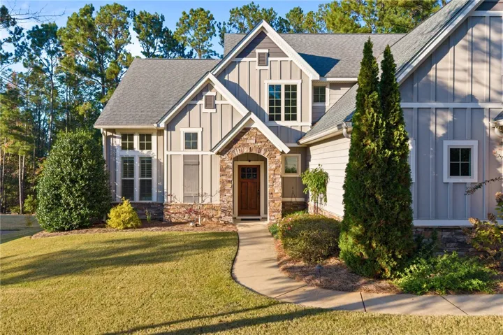 An inviting stone archway frames the wood entry door of this multi-level home.