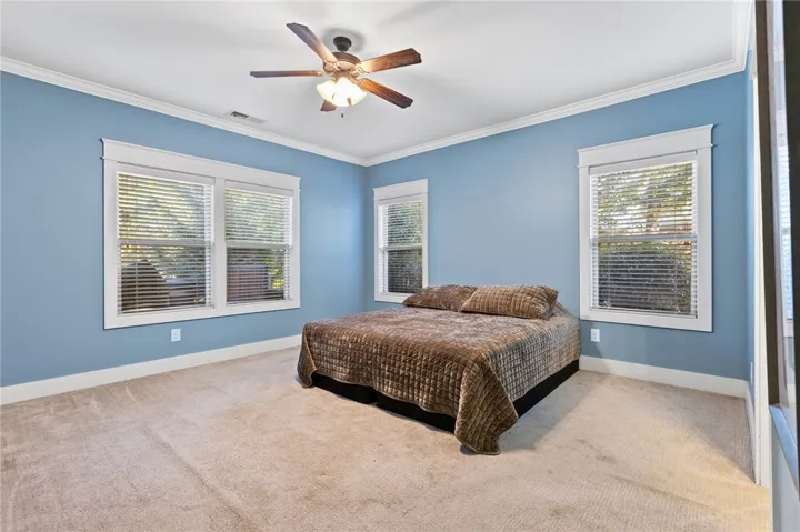 Plentiful windows invite natural light into this spacious room highlighted by classic crown molding.