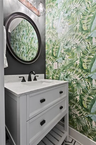 A stylish vanity paired with stone countertops defines this contemporary powder room.