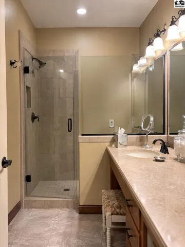 Custom onyx and glass shower with bench seat.