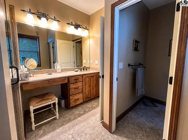 Master bathroom with two separate vanities with sheet glass mirrors, onyx countertops & sinks.