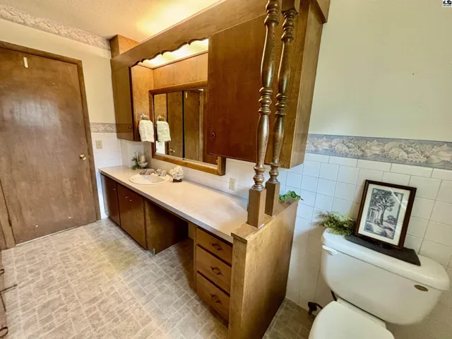 Hall bathroom by bedrooms is LOADED with storage w/full wall of cabinets to the large vanity.