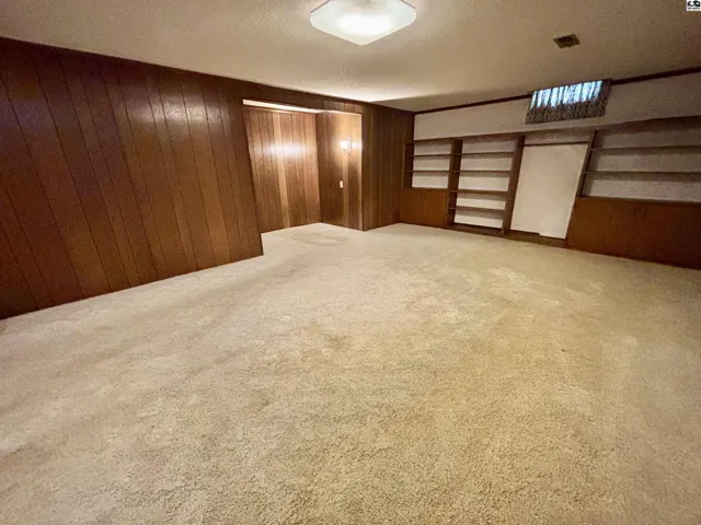Wall of shelving and a nook housed a desk, also has access to mechanical room.