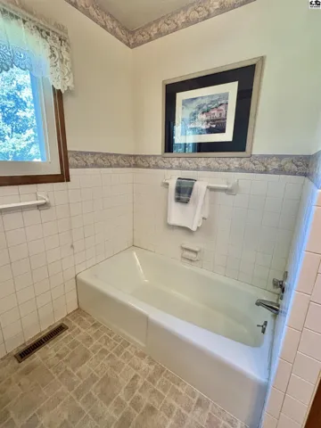Tiled surrounds the original bath tub. Can you add a shower, absolutely!