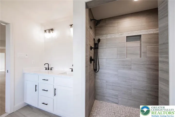 Attention to detail shines through. Beautifully tiled primary bath with custom shower, double vanity and soaking tub.