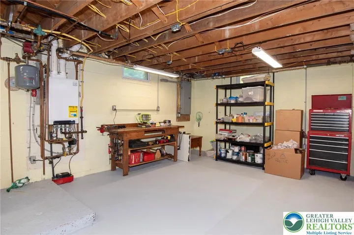 Utilities are all located on one wall. Electric panel, hot water on demand tank on wall.